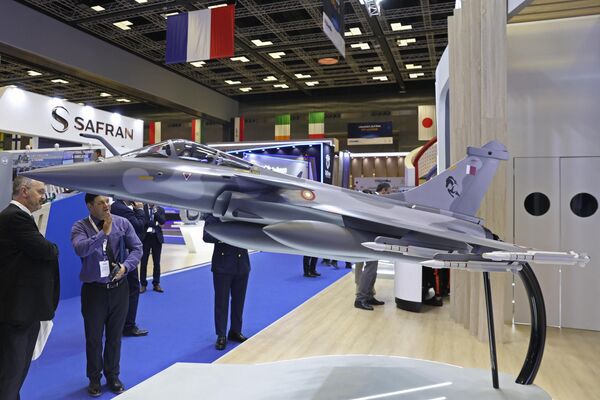 بازدیدکنندگان مدلی از جت جنگنده قطر را که در نمایشگاه و کنفرانس بین‌المللی دفاع دریایی دوحه (DIMDEX 2024) در مرکز همایش ملی قطر در دوحه در 6 مارس 2024 به نمایش گذاشته شده است، نگاه می‌کنند. - اسپوتنیک ایران  