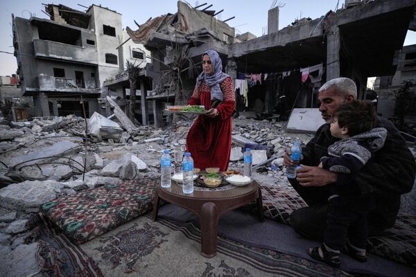 افطار خانواده فلسطینی الناجی در اولین روز از ماه مبارک رمضان در دیرالبلاح در مرکز نوار غزه در میان ویرانه های خانه خود. - اسپوتنیک ایران  
