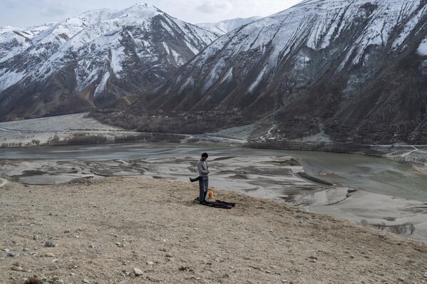 نمازخواندن یک معدنچی افغان در کنار معدن طلا در بدخشان افغانستان. - اسپوتنیک ایران  