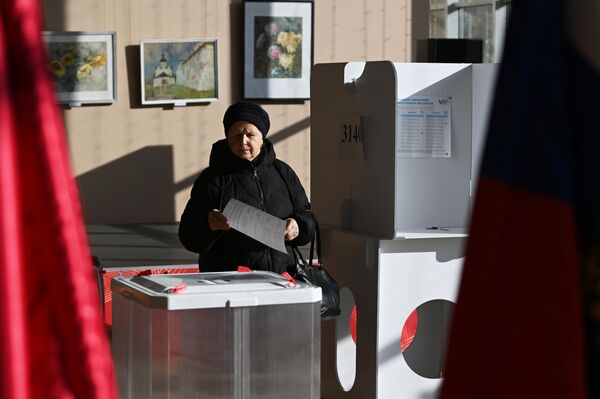 یک زن در انتخابات ریاست جمهوری روسیه در یک مرکز رای گیری در مسکو رای می دهد. - اسپوتنیک ایران  