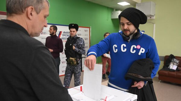 Мужчина голосует на выборах президента России на избирательном участке школы №2123 в Москве - اسپوتنیک ایران  