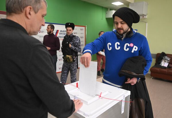 مردی در انتخابات ریاست جمهوری روسیه در شعبه رای گیری مدرسه شماره 2123 مسکو رای می دهد. - اسپوتنیک ایران  