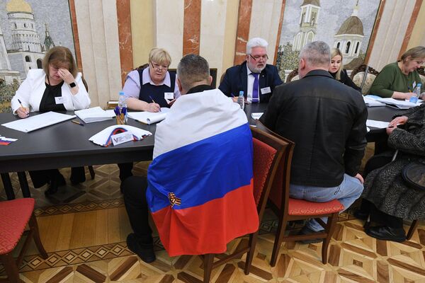 مردم در جریان انتخابات ریاست جمهوری روسیه در یک شعبه رای گیری در سفارت روسیه در مینسک رای می دهند. - اسپوتنیک ایران  