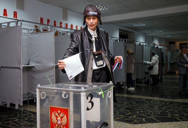 مردی در یک مرکز رای گیری در خانه افسران ارتش روسیه در تیراسپول در جریان انتخابات ریاست جمهوری روسیه رای می دهد. - اسپوتنیک ایران  