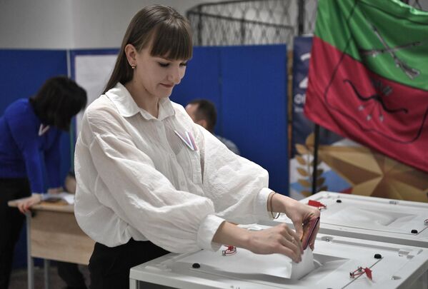 یک زن در انتخابات ریاست جمهوری روسیه در یک مرکز رای گیری در کنستانتینوفکا رای می دهد. - اسپوتنیک ایران  