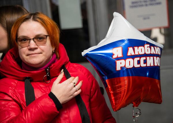 یک زن در انتخابات ریاست جمهوری روسیه در یک مرکز رای گیری در اسکادوسک رای می دهد. - اسپوتنیک ایران  