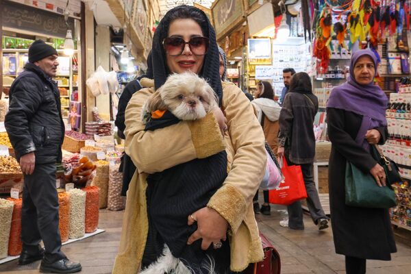 خانم ایرانی و سگش در حال خرید نوروزی در بازار تهران. - اسپوتنیک ایران  