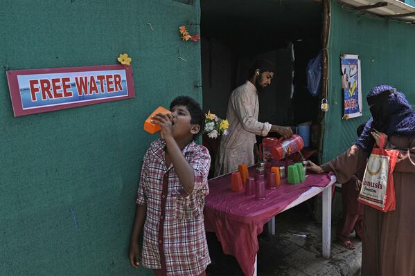یک داوطلب در یک روز گرم تابستانی در حیدرآباد، هند، پنج‌شنبه، 21 مارس 2024، آب آشامیدنی را در کنار ایستگاه اتوبوس توزیع می‌کند. مردم در بسیاری از مناطق هند در ماه‌های تابستان آب آشامیدنی رایگان در اختیار مسافران قرار می‌دهند. جمعه مصادف با روز جهانی آب است - اسپوتنیک ایران  