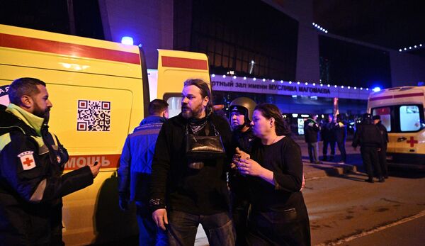 کارکنان سرویس های اورژانس به مردم در نردیکی سالن کنسرت کروکوس سیتی در حومه مسکو کمک می کنند، جایی که تیراندازی رخ داد. حداقل سه نفر با لباس نظامی  آتش گشودند و تعدادی  کشته و زخمی شدند. - اسپوتنیک ایران  