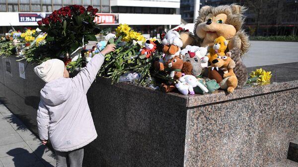 Девочка возлагает цветы к стихийному мемориалу в Симферополе во время акции в память о жертвах теракта в подмосковном Крокус Сити Холле - اسپوتنیک ایران  