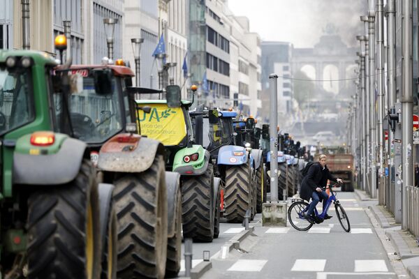 کشاورزان با تراکتورهای خود در یک بلوار اصلی منتهی به ساختمان شورای اروپا در بروکسل، سه شنبه، 26 مارس 2024، صف می کشند. ده ها تراکتور خیابان های نزدیک به مقر اتحادیه اروپا را مسدود کردند که وزیران کشاورزی 27 کشور عضو اتحادیه اروپا در آنجا نشستی برای بحث و گفتگو درباره بحران در بخش کشاورزی برگزاری می کنند که به ماه ها تظاهرات در کشورهای اروپایی منجر شده است. - اسپوتنیک ایران  