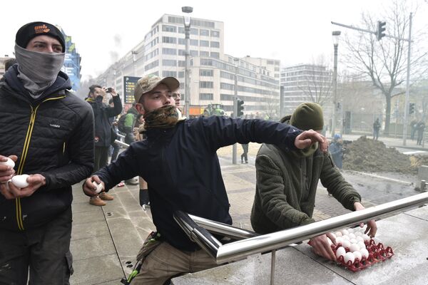 معترضان در حین تظاهرات در نزدیکی ساختمان شورای اروپا در بروکسل، سه شنبه، 26 مارس 2024، به سمت پلیس تخم مرغ پرتاب کردند. ده ها تراکتور خیابان های نزدیک به مقر اتحادیه اروپا را مسدود کردند که وزیران کشاورزی 27 کشور عضو اتحادیه اروپا در آنجا نشستی برای بحث و گفتگو درباره بحران در بخش کشاورزی برگزاری می کنند که به ماه ها تظاهرات در کشورهای اروپایی منجر شده است. - اسپوتنیک ایران  