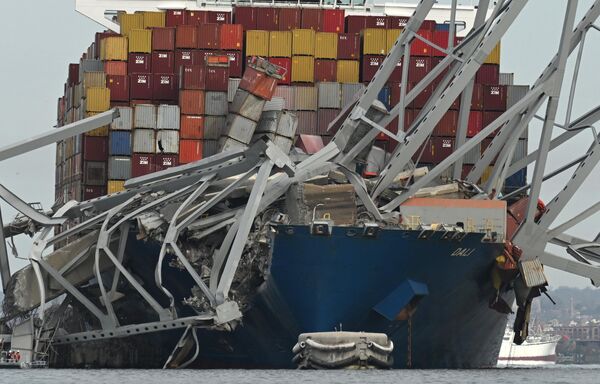 بخشی از قاب فولادی پل فرانسیس اسکات کی بر روی کشتی کانتینری دالی پس از فروریختن پل در بالتیمور، مریلند، در 26 مارس 2024، بر بالای کشتی کانتینری دالی قرار دارد. این پل  26 مارس پس از برخورد کشتی کانتینربر دالی با پرچم سنگاپور با آن فروریخت. هیچ روایتی  در مورد علت فاجعه وجود ندارد، اما کمیسر پلیس بالتیمور، ریچارد ورلی، گفت &quot;هیچ نشانه ای&quot; از تروریسم وجود ندارد. - اسپوتنیک ایران  