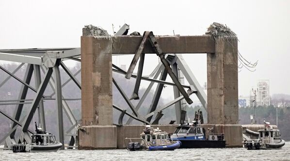 قایق های غواصی پلیس در اطراف بخشی از ساختار پل فرانسیس اسکات کی پس از برخورد کشتی با پل در چهارشنبه، 27 مارس 2024، در بالتیمور کار می کنند. - اسپوتنیک ایران  