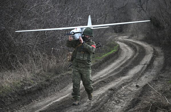 یک اپراتور پهپاد گروه مرکزی ارتش روسیه یک پهپاد Orlan-30 را پس از به کار انداختن در جبهه آودیوکا عملیات نظامی ویژه با خود می برد - اسپوتنیک ایران  