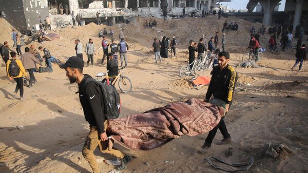 Палестинцы выносят тело из разрушенной больницы Аль-Шифа в Газе после того, как израильские военные покинули комплекс - اسپوتنیک ایران  