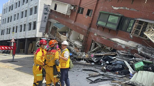 اعضای یک تیم جستجو و نجات پس از زلزله در هیالین ، شرق تایوان، چین، در نزدیکی یک ساختمان آسیب دیده  ایستاده اند. - اسپوتنیک ایران  