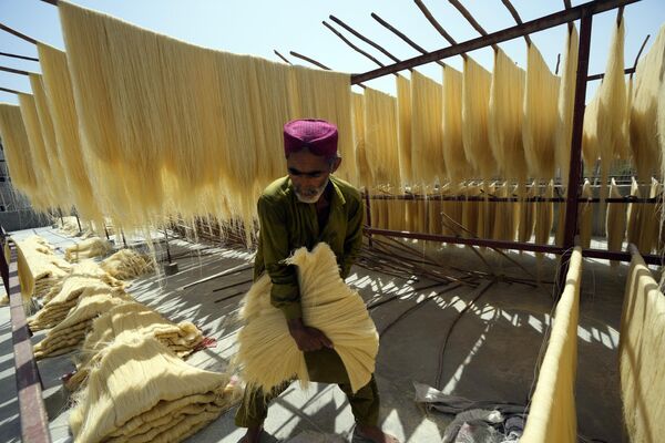 یک کارگر در کارخانه ای در کراچی، پاکستان، رشته فرنگی سنتی ورمیشل را تهیه می کند که مورد علاقه در ماه مبارک رمضان است. - اسپوتنیک ایران  