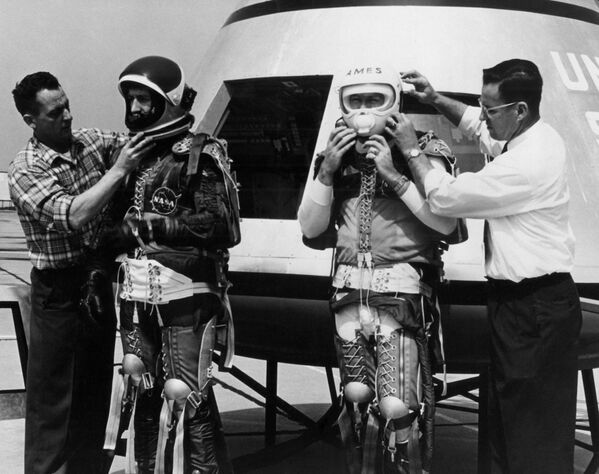 آمادگی سه نفر از پرسنل ناسا با تجهیزات مهار کننده پرواز فضایی برای صعود به فضاپیمای آپولو در 6 آوریل 1962. - اسپوتنیک ایران  