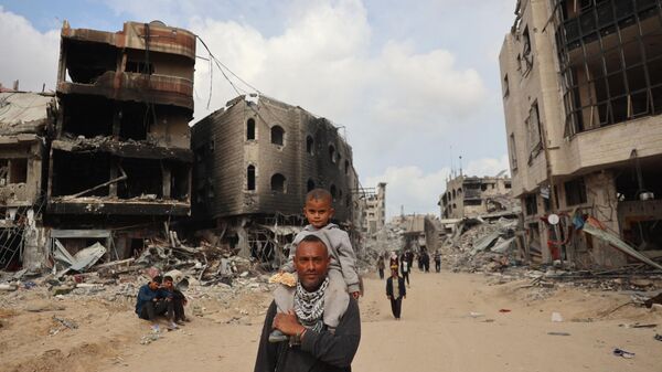 Палестинцы проходят мимо разрушенных зданий в Хан-Юнисе, Палестина - اسپوتنیک ایران  