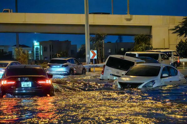 به دنبال باران‌های شدید در دوبی در 17 آوریل 2024، اتومبیل‌ها در خیابانی پر آب حرکت می کنند. دوبی، مرکز مالی خاورمیانه، در اثر باران سیل آسا فلج شده بود  که باعث سیل در امارات و بحرین شد و 18 کشته در عمان در روزهای  14 و 15 آوریل برجای گذاشت.  - اسپوتنیک ایران  