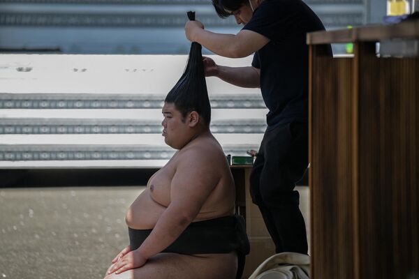 آرایش موی یک کشتی گیر سومو قبل از شرکت در نمایشگاه سالانه &quot;هونوزومو&quot;،  در معبد یاسوکونی در توکیو. - اسپوتنیک ایران  