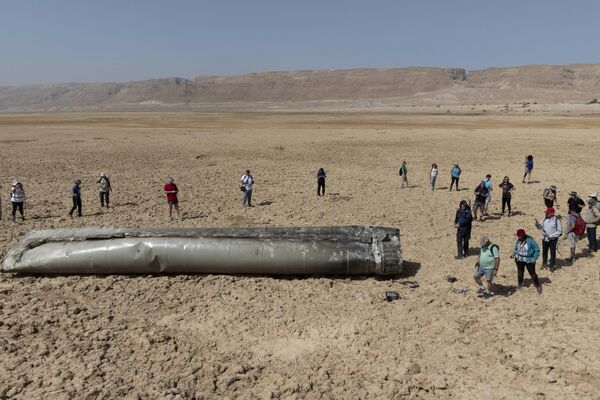 جمع شدن مردم در اطراف یکی از اجزای یک موشک بالستیک رهگیری شده که در نزدیکی دریای مرده در اسرائیل سقوط کرده است. - اسپوتنیک ایران  