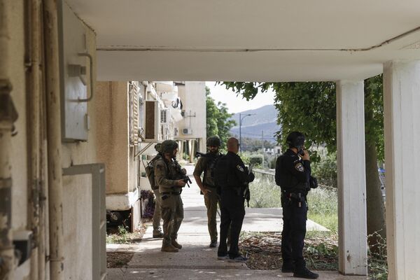 نیروهای امنیتی و پرسنل اورژانس در محل اصابت موشک از جنوب لبنان به شهر کریات شمونه در شمال اسرائیل. - اسپوتنیک ایران  