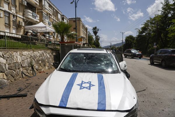 خودروی منهدم شده بر اثر اصابت موشک پرتاب شده از جنوب لبنان به شهر کریات شمونه در شمال اسرائیل. - اسپوتنیک ایران  