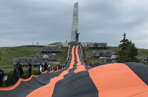 شرکت کنندگان در حرکتی  که به جشن روز پیروزی اختصاص داشت، روبان سنت جورج  به طول 300 متر را در مجموعه یادبود &quot;سائور ماگیلا&quot;  در جمهوری خلق دونتسک به نمایش گذاشتند. - اسپوتنیک ایران  