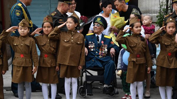 مردم به آسک اورمانبتوف، کهنه سرباز 101 ساله جنگ میهنی، در جشن های روز پیروزی در بیشکک، قرقیزستان، تبریک می گویند. - اسپوتنیک ایران  