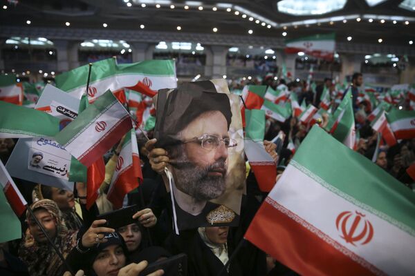 16 می 2017، هواداران ابراهیم رئیسی عکس او را در دست گرفته و پرچم کشورشان را در جریان راهپیمایی انتخابات ریاست جمهوری 2017 در تهران به اهتزاز در آوردند. - اسپوتنیک ایران  