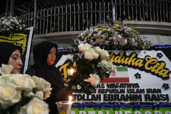 زنان در مراسم شمع‌افروزی به یاد ابراهیم رئیسی رئیس‌جمهور ایران در مقابل سفارت ایران در جاکارتا، اندونزی. - اسپوتنیک ایران  