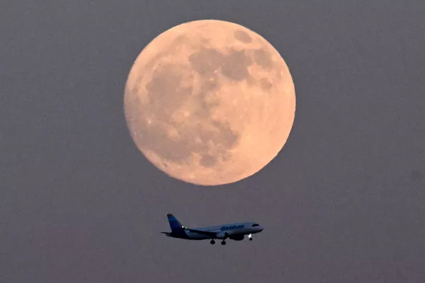 یک هواپیما در 22 مه 2024 در شهرفرانکفورت آم ماین در غرب آلمان، از برابر ماه کامل عبور می کند. - اسپوتنیک ایران