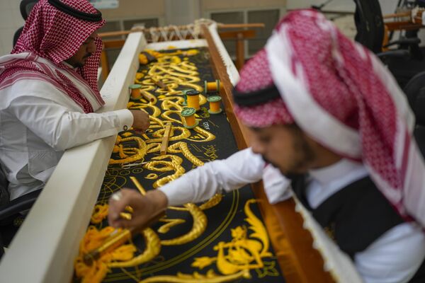 مردان سعودی با استفاده از نخ‌های نقره خالص یا نخ‌های نقره‌ای که با طلا روکش شده ، در حال به پایان رساندن کار دوختن پرده کعبه هستند. پنجشنبه، 13 ژوئن 2024. - اسپوتنیک ایران  
