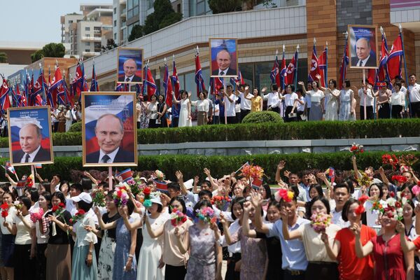 19 ژوئن 2024. مردم از ولادیمیر پوتین رئیس جمهور روسیه در خیابان های پیونگ یانگ استقبال می کنند. - اسپوتنیک ایران  