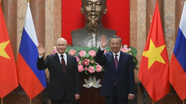 ولادیمیر پوتین رئیس‌جمهور روسیه و رئیس‌ جمهوری سوسیالیستی ویتنام، تو لام در حال گرفتن عکسی مشترک در کاخ ریاست‌جمهوری در هانوی - اسپوتنیک ایران  