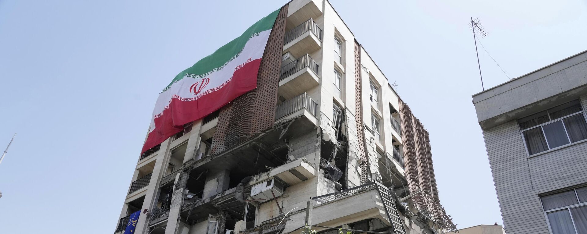 Иранский флаг висит на здании, которое подверглось израильскому удару в Тегеране - اسپوتنیک ایران  , 1920, 30.06.2025