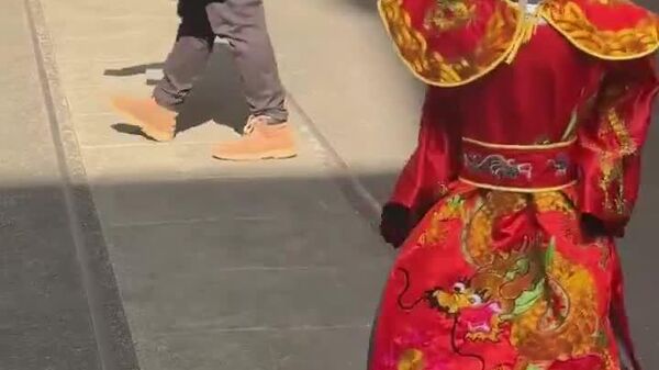 یک ربات با لباس خدای ثروت چینی که در شهر شانگهای این کشور دیده شده - اسپوتنیک ایران  