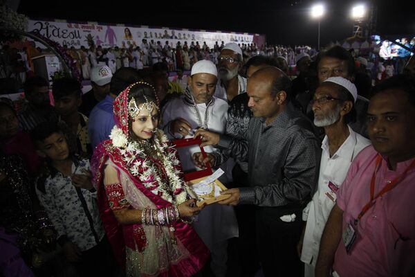 ماهش ساوانی، تاجر الماس هندی در مراسم عروسی گروهی در شهر سورات هند به عروس مسلمانی به نام نجمه بیگم قدری، هدایایی تقدیم می کند - اسپوتنیک ایران  