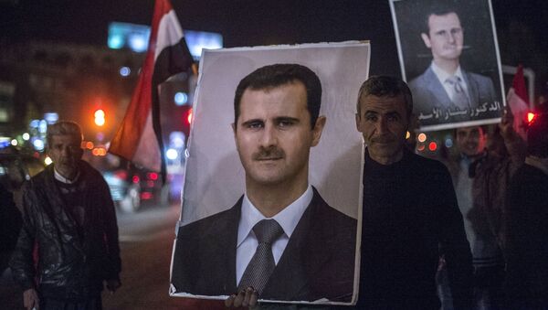 Жители Дамаска держат портреты сирийского президента Башара Асада во время встречи военнослужащих Сирийской арабской армии, участвовавших в снятии блокады с авиабазы Квейрис в провинции Алеппо - اسپوتنیک ایران  