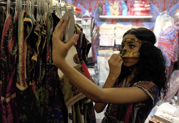 زن سعودی که در فروشگاهی ماسک بر چهره می زند - اسپوتنیک ایران  