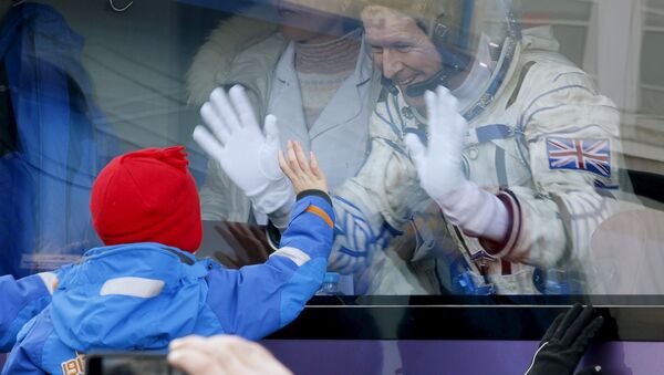 Британский астронавт Тимоти Пик машет детям из салона автобуса перед старт космического корабля Союз ТМА-19М с космодрома Байконур, Казахстан - اسپوتنیک ایران  
