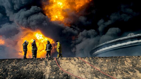 Пожарные на фоне горящего нефтехранилища в городе Рас-Лануф в Ливии - اسپوتنیک ایران  