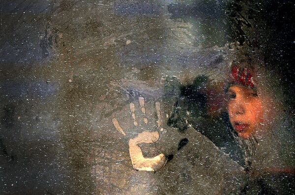 پسری پشت پنجره یخ زده اتوبوس در مینسک - اسپوتنیک ایران  