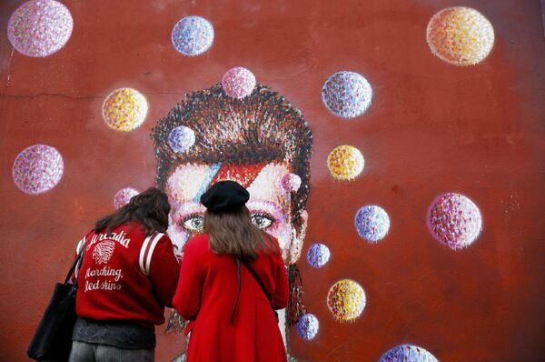 دختری در جلوی گرافیتی دیوید بوئی در لندن - اسپوتنیک ایران  