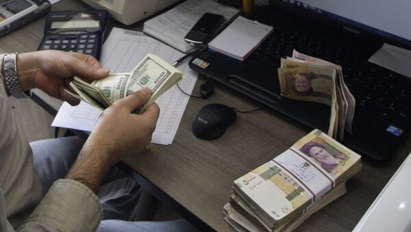 A currency exchange bureau worker counts US dollars, as Iranian bank notes are seen at right with portrait of late revolutionary founder Ayatollah Khomeini. - اسپوتنیک ایران  