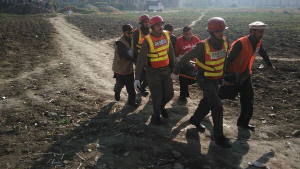 Пакистанские спасатели несут пострадавшего во время террористической атаки на университет в городе Чарсадда - اسپوتنیک ایران  