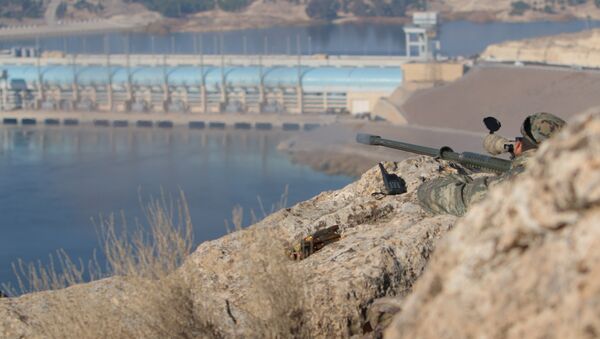 A sniper from the Democratic Forces of Syria takes an overwatch position at the top of Mount Annan overlooking the Tishrin dam, after they captured it on Saturday from Islamic State militants, south of Kobani, Syria December 27, 2015 - اسپوتنیک ایران  