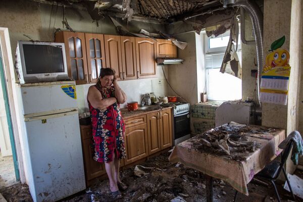 زنی در خانه خود پس از آتشباری شبانه از طرف نظامیان اوکراین در حومه اسلاویانسک - اسپوتنیک ایران  